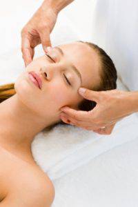Closeup of a beautiful young woman receiving face massage